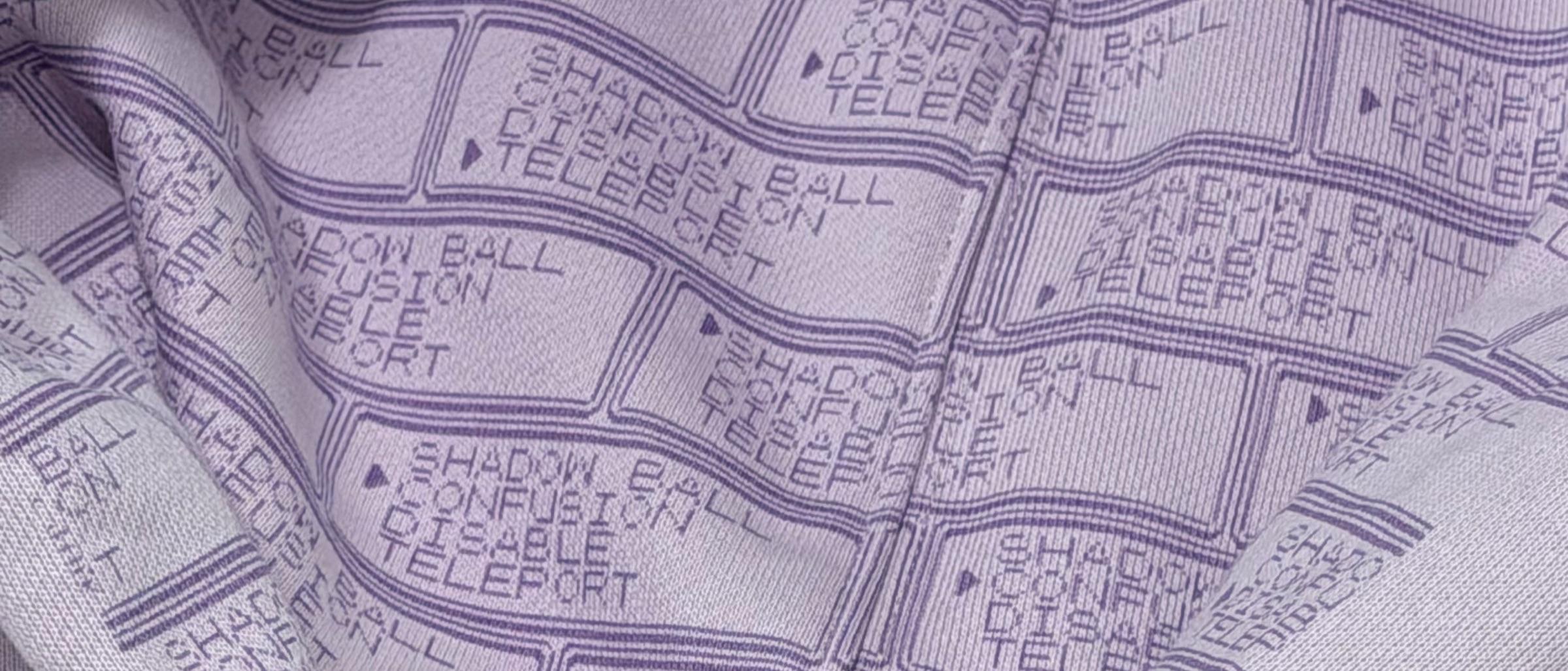 Inside the hood of The 150 Hoodie: a lavender lining printed with a repeating pixel-font battle menu